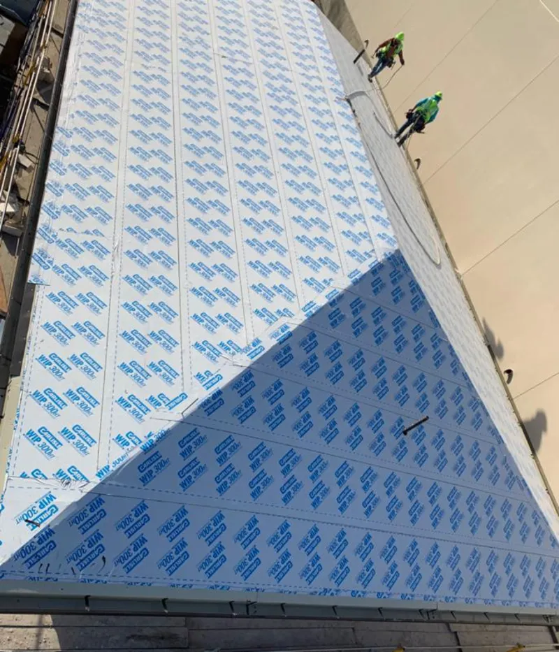 Professional roofers installing underlayment on a metal roof in Sudley